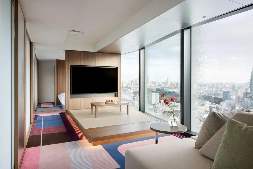 Un salon moderne avec canapé et table basse offre une vue sur la ville.