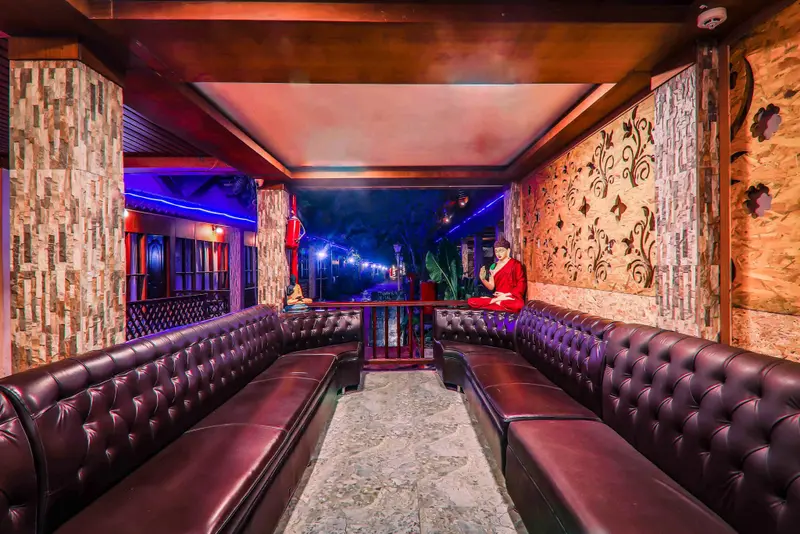 Espace de détente intérieur avec banquettes en cuir et éclairage coloré.