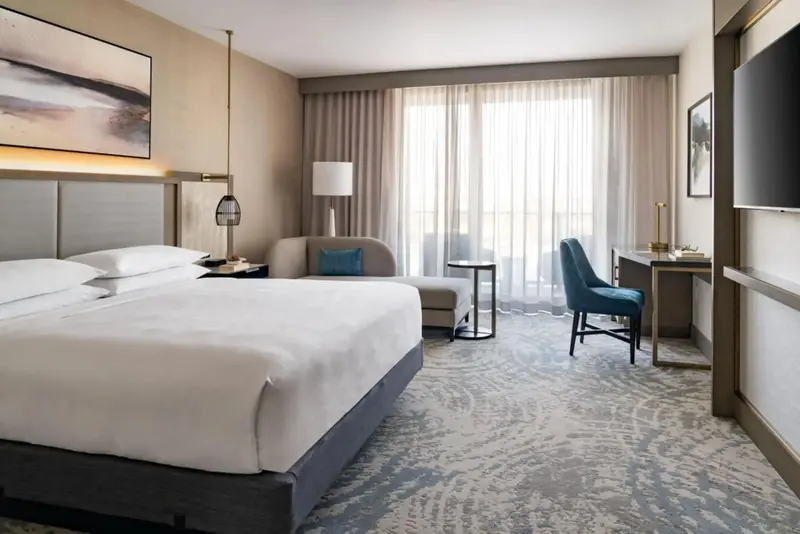 Une chambre lumineuse avec un grand lit et un espace bureau.