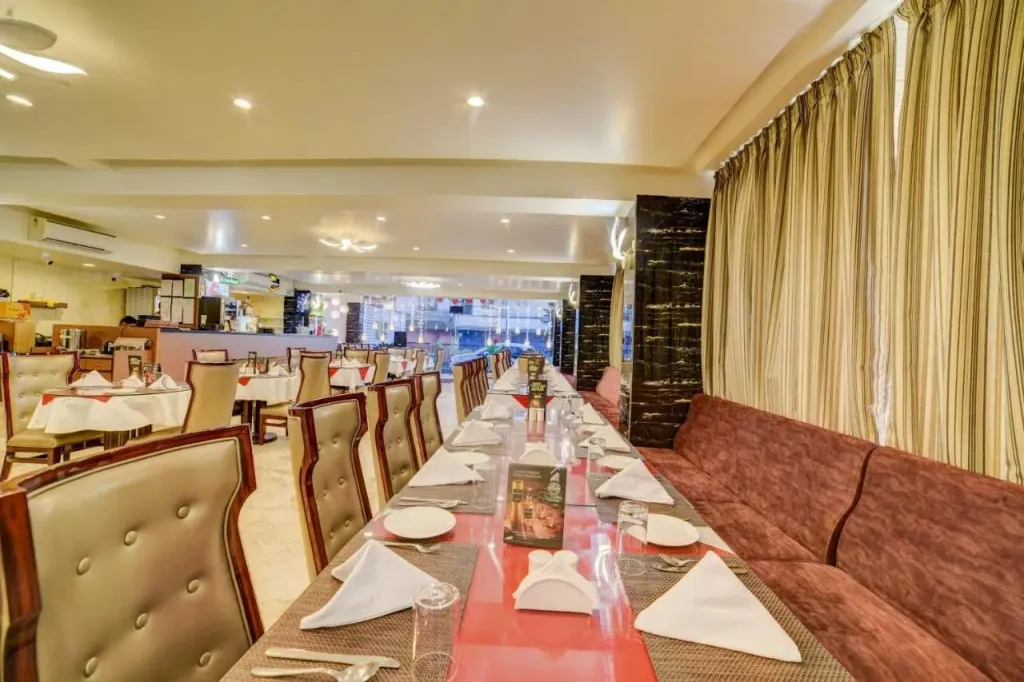 Une salle de restaurant lumineuse avec des tables dressées et des banquettes.