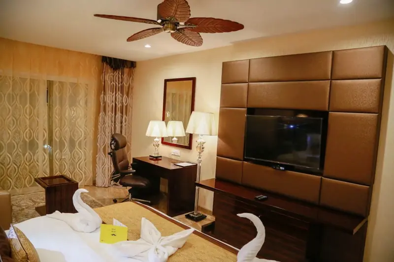 Une chambre à coucher lumineuse avec un bureau et une télévision.