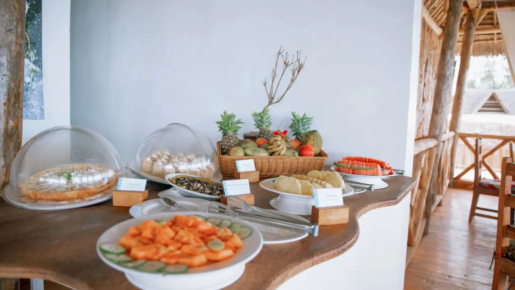 Un buffet propose des pâtisseries, des fruits frais et des crudités.