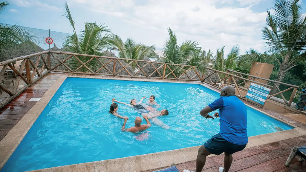 Des personnes se rafraîchissent dans une piscine en bord de mer.