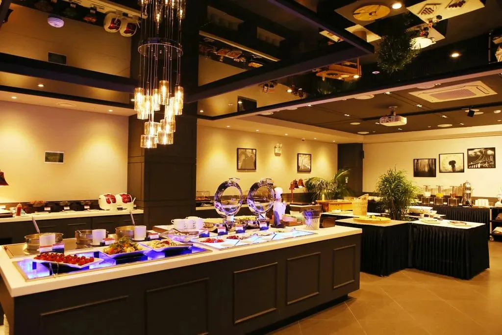 Un buffet de nourriture est présenté dans une salle lumineuse et décorée.