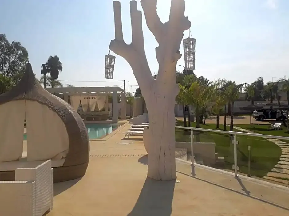 Une piscine bordée de chaises longues et d'un espace détente ombragé.
