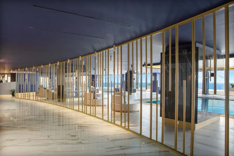 Un long couloir lumineux mène vers un espace de détente avec vue sur la mer.