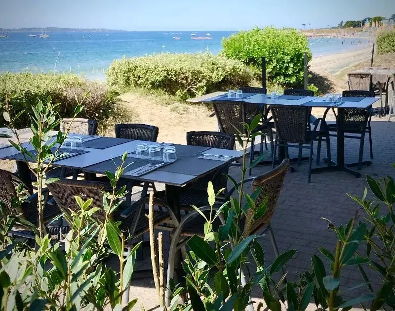 Tables dressées en terrasse avec vue sur la mer.