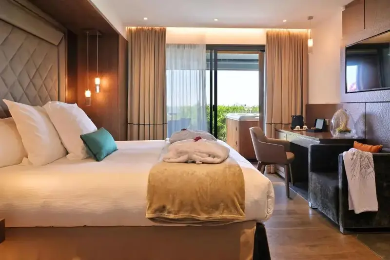 Une chambre lumineuse avec un grand lit et un accès à une terrasse.