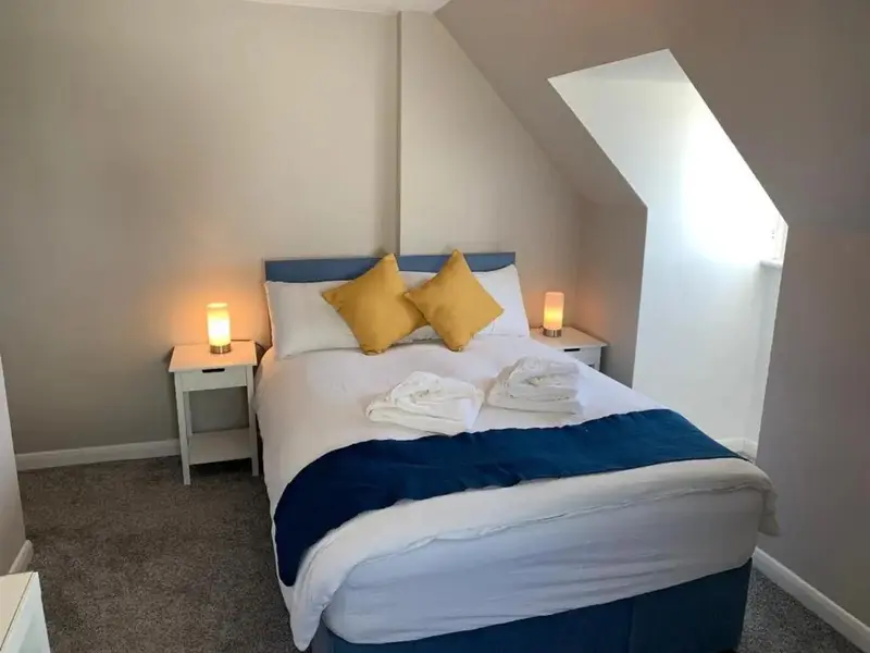 Une chambre lumineuse avec un lit double et des oreillers décoratifs.