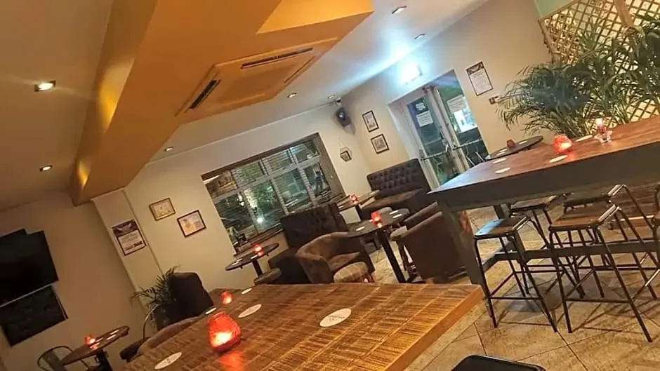 Une salle lumineuse avec des tables et des fauteuils confortables.