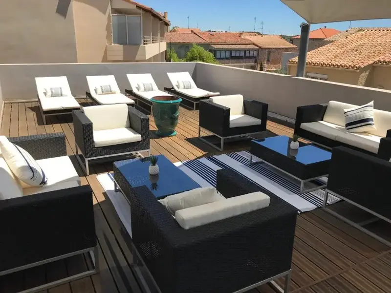 Espace de détente extérieur aménagé avec des salons et des transats.