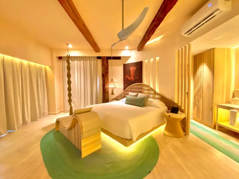 Une chambre lumineuse avec un grand lit et une décoration chaleureuse.