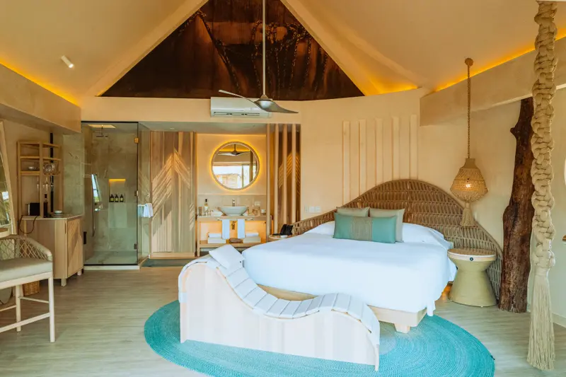 Une chambre lumineuse avec un grand lit et un espace détente.