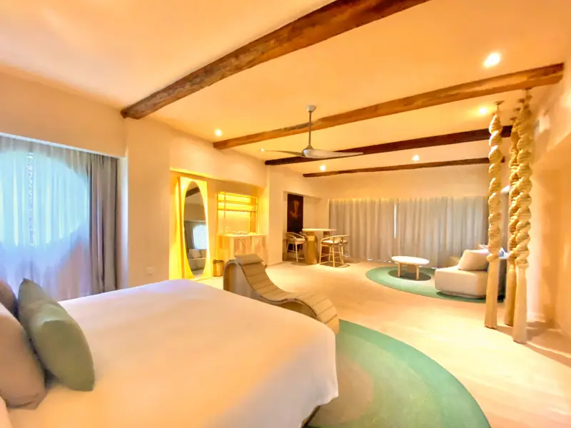 Une chambre lumineuse avec un grand lit et un espace détente.