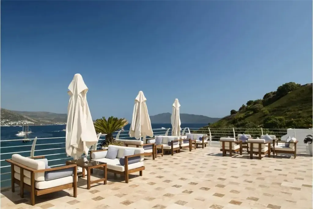Terrasse aménagée avec des salons et des transats offrant une vue sur la mer.