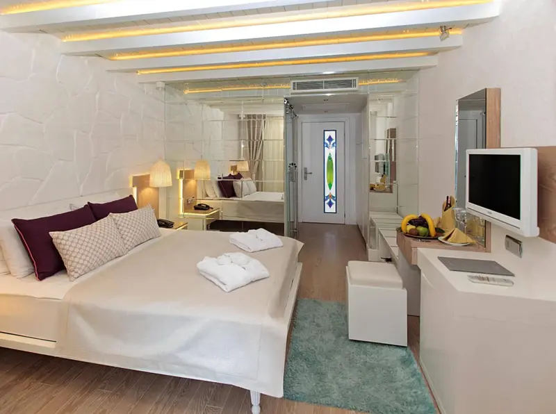 Une chambre lumineuse avec un grand lit et une télévision à écran plat.
