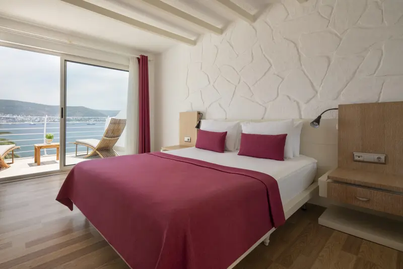 Une chambre lumineuse avec un grand lit et une vue sur la mer.