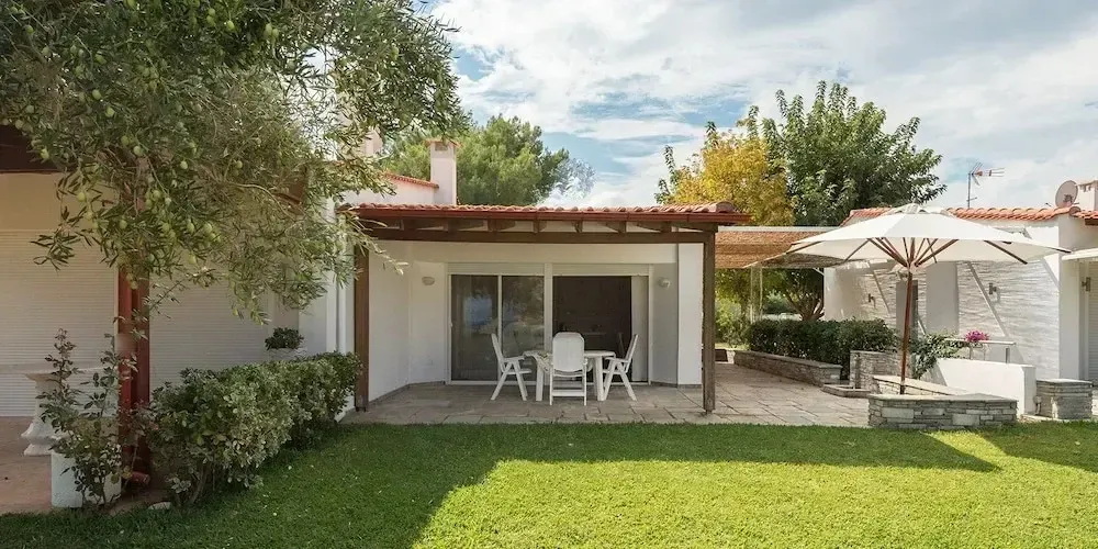 Terrasse ombragée donnant sur un jardin verdoyant.