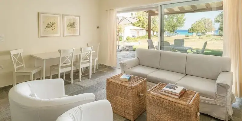 Espace de vie lumineux avec coin repas et accès à une terrasse donnant sur la mer.