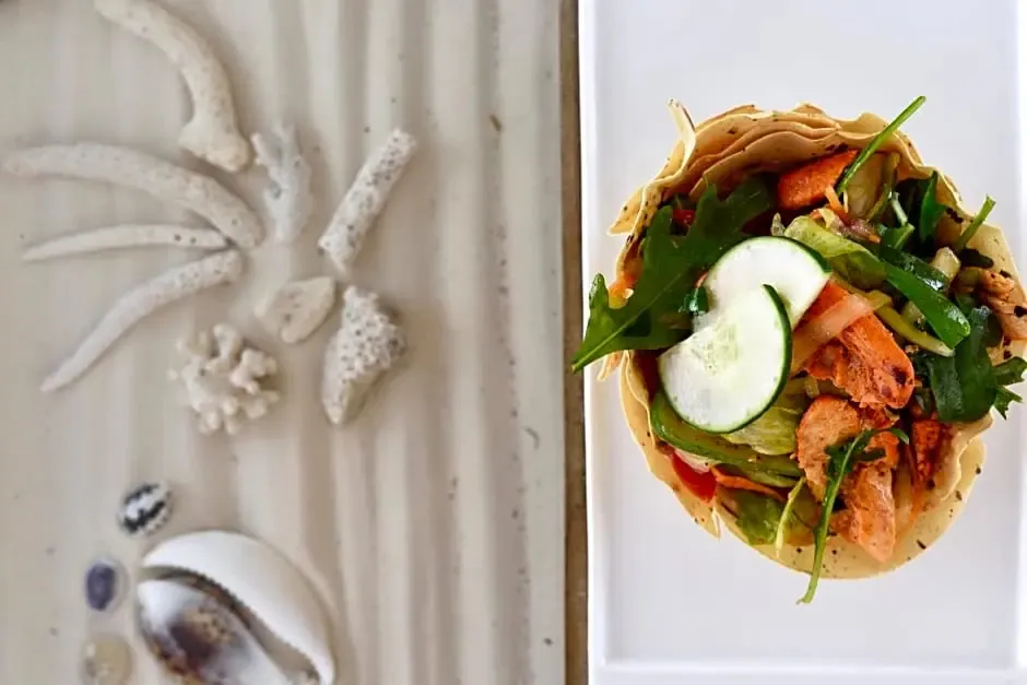 Assiette présentée avec une préparation culinaire et des éléments décoratifs marins.
