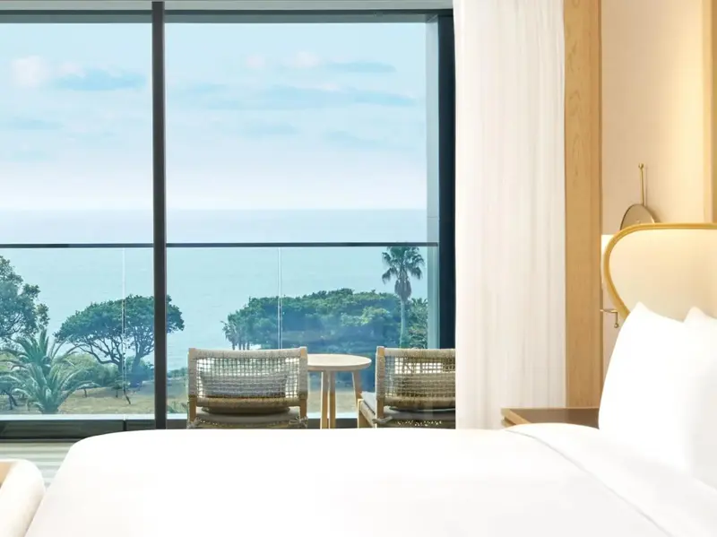 Une chambre lumineuse avec vue sur la mer et un coin salon.