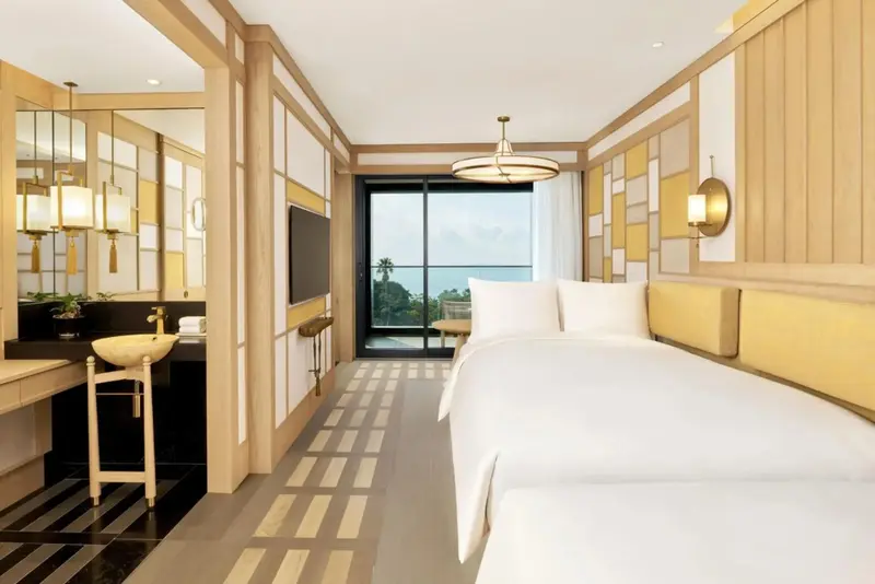 Une chambre lumineuse avec un grand lit et une vue sur la mer.