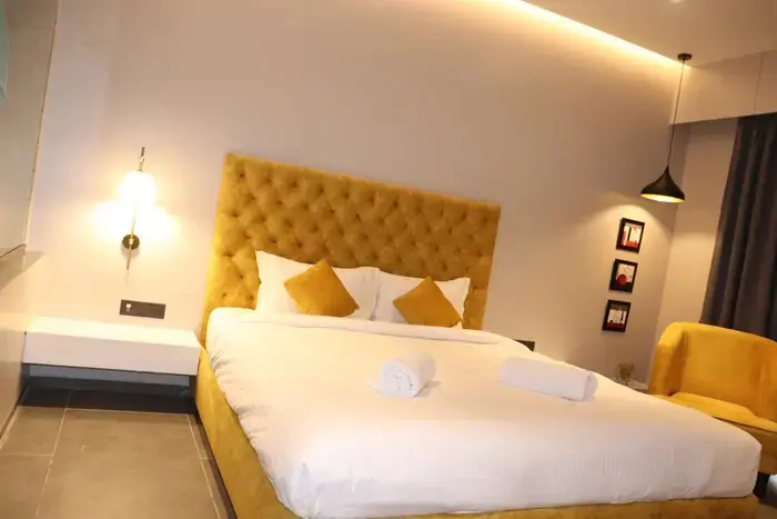 Une chambre lumineuse avec un grand lit et une décoration jaune.