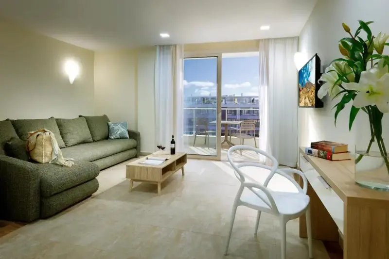 Un salon lumineux s'ouvre sur une terrasse avec vue sur la mer.