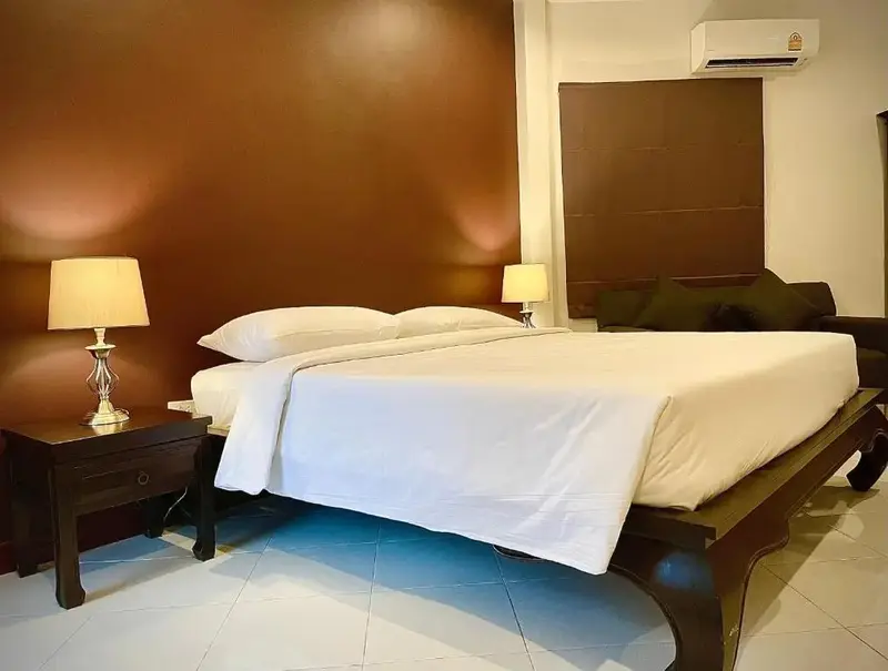 Une chambre à coucher avec un grand lit recouvert de draps blancs et deux lampes de chevet.
