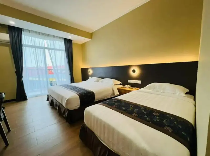 Une chambre lumineuse avec deux lits et une fenêtre.
