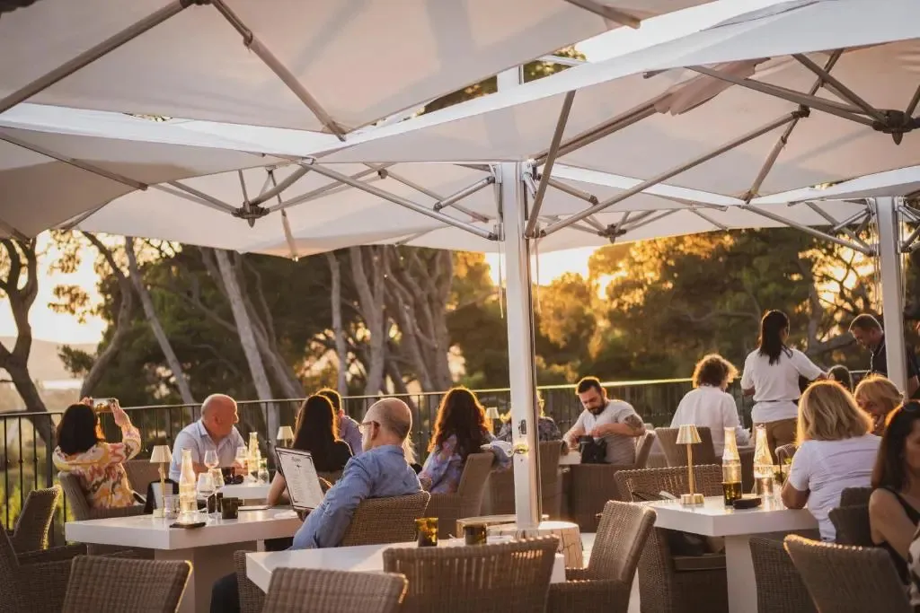 Une terrasse ombragée avec des tables et des chaises accueillant des convives.