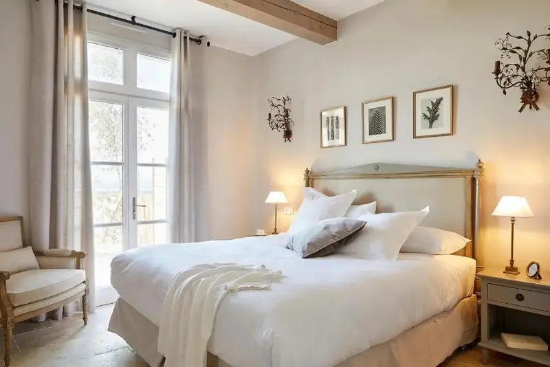 Une chambre lumineuse avec un grand lit et un accès à une terrasse.