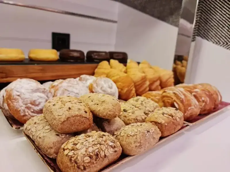 Présentation de viennoiseries et de pâtisseries sur des plateaux.
