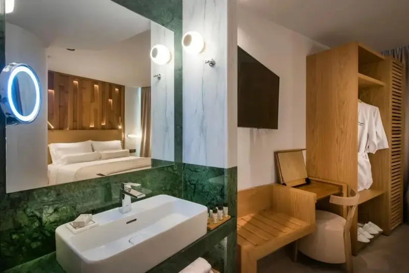 Une chambre moderne avec un grand miroir et un lavabo intégré.