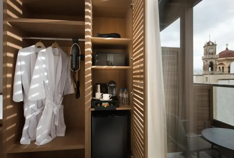 Un espace de rangement avec peignoirs et un coin café dans une chambre d'hôtel.