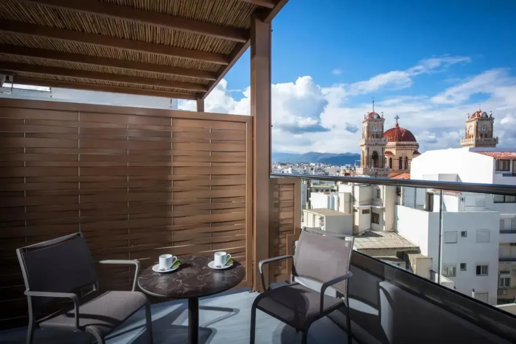 Terrasse avec mobilier et vue sur une ville.