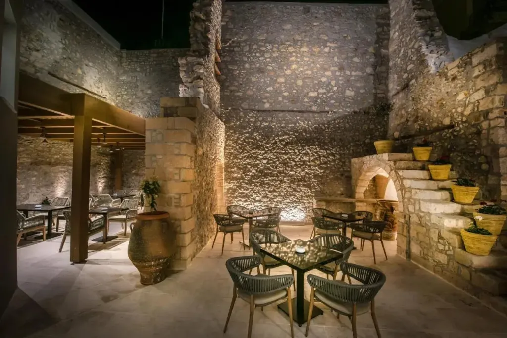 Une cour intérieure éclairée avec des tables et des chaises.