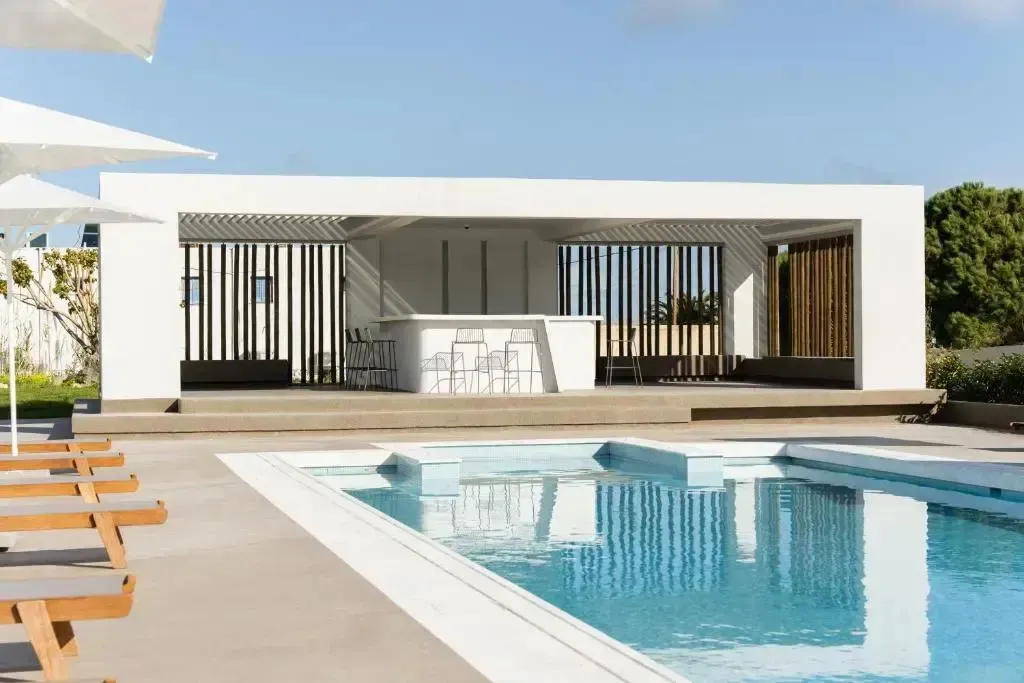 Une piscine rectangulaire avec un bar en fond.