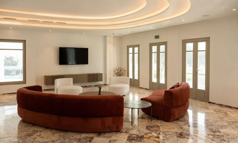 Un espace de détente intérieur avec des canapés et un téléviseur mural.