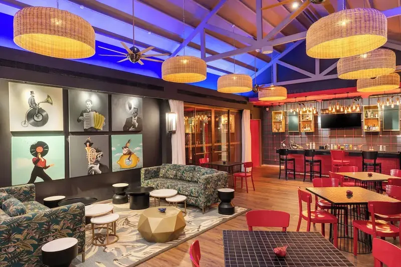 Un espace de détente intérieur avec canapés, tables basses et un comptoir de bar.