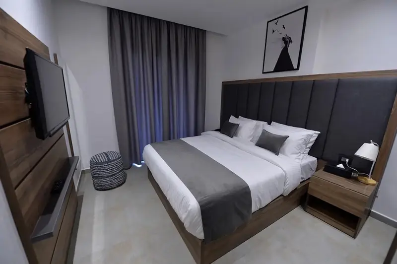 Une chambre moderne avec un grand lit et une télévision murale.