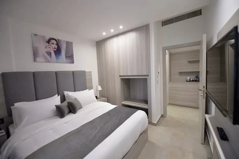 Une chambre moderne avec un grand lit et un espace ouvert sur une autre pièce.