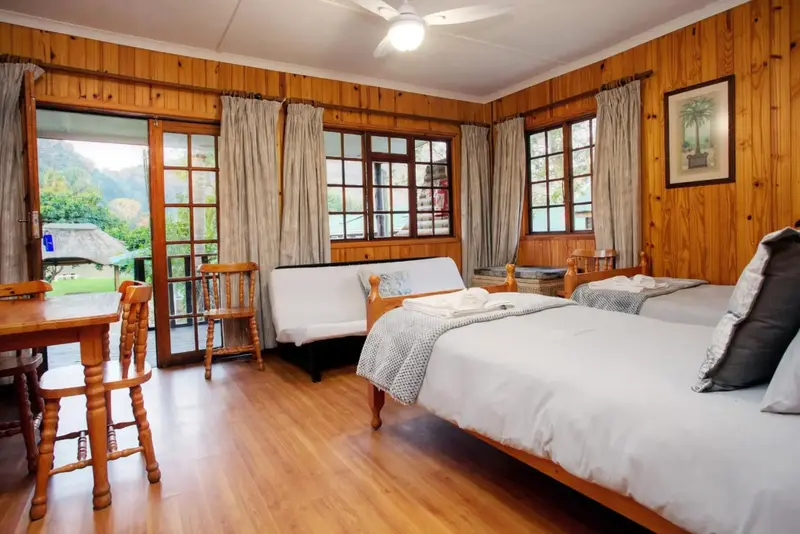 Une chambre lumineuse avec un lit et un coin repas près d'une porte-fenêtre.