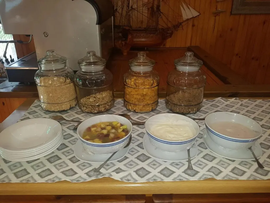 Des céréales et des fruits sont présentés dans des récipients sur un comptoir.