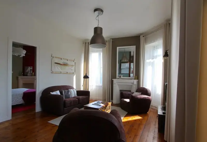 Un salon chaleureux avec canapés et fauteuils confortables.