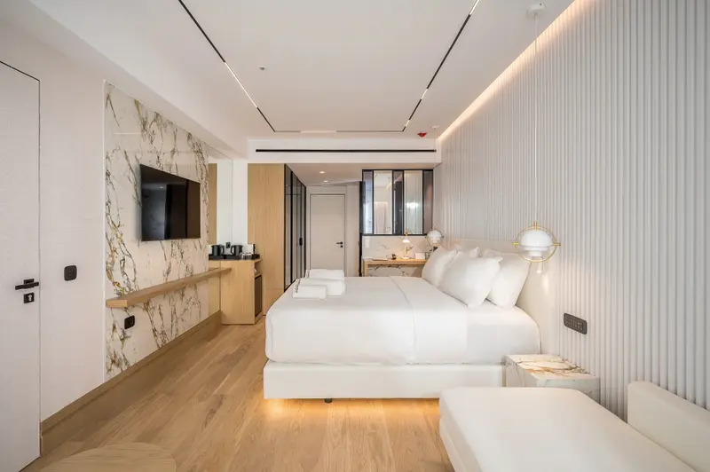 Une chambre lumineuse avec un grand lit et une décoration moderne.