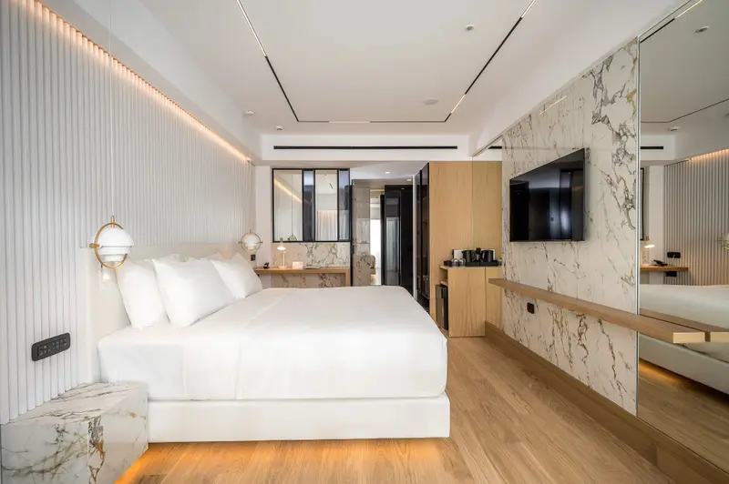 Une chambre lumineuse avec un grand lit et un décor moderne.