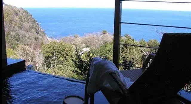 Vue sur la mer depuis une terrasse avec mobilier de jardin.