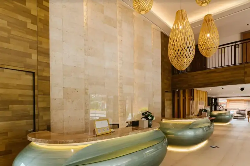 Un comptoir d'accueil moderne avec un mur texturé et des luminaires décoratifs.