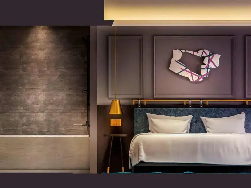 Une chambre moderne avec un grand lit et un mur décoratif.